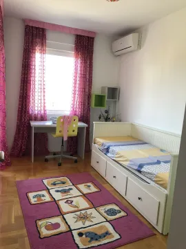 A bright children's bedroom with a bed, study desk, and a colorful rug. - image 14