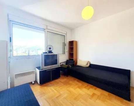Living room with a sofa, television, and parquet flooring. - image 3