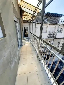 Enclosed balcony with tile flooring and a metal railing. - image 16