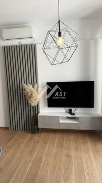 Dnevna soba sa televizorom, modernim lusterom i dekorativnim drvenim panelima na zidu. - image 5