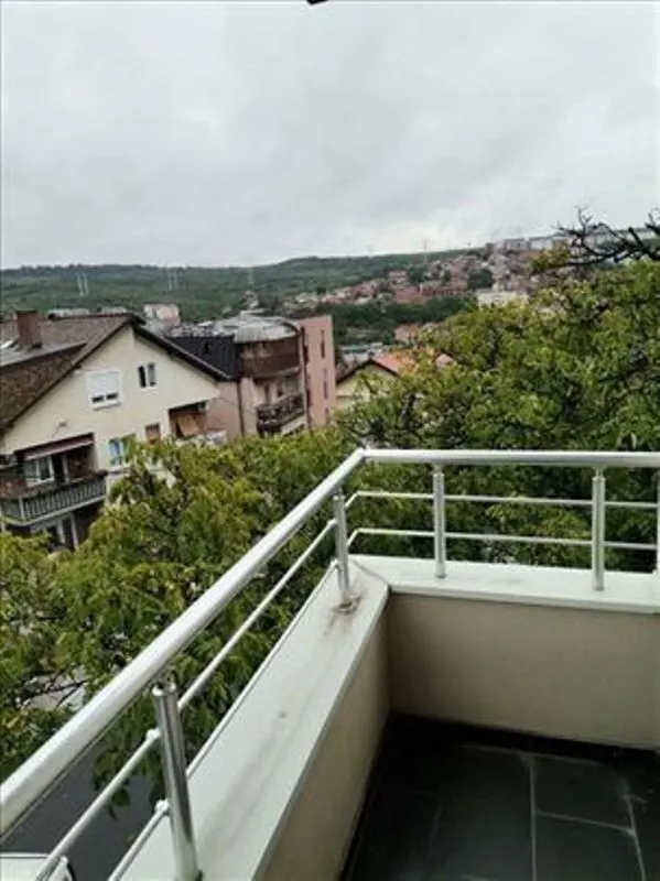 Pogled sa balkona na okolne kuće i zelenilo.