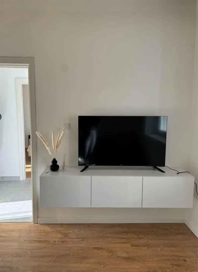 Dnevna soba sa televizorom na bijeloj zidnoj komodi.