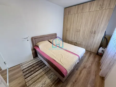 Nameštena spavaća soba sa bračnim krevetom i velikim drvenim ormarom. - image 13