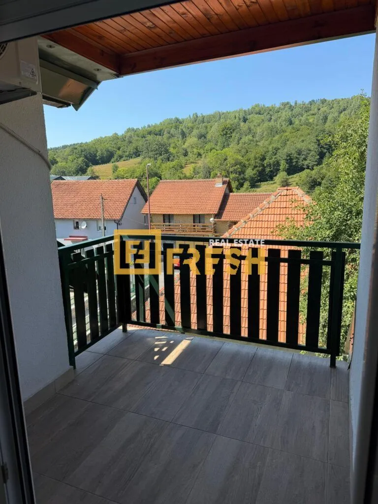 Natkriveni balkoni sa pogledom na susjedne kuće i zelenilo.