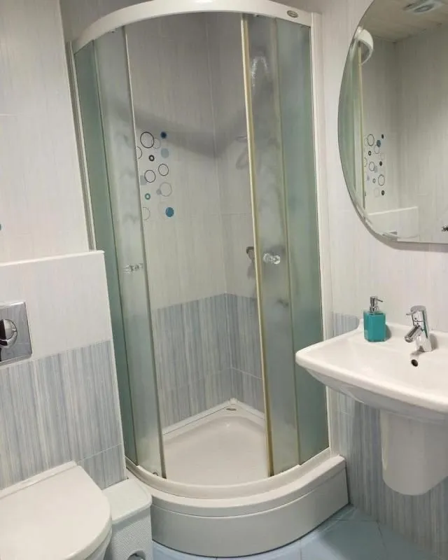 Bathroom with a shower cabin, washbasin, and mirror.