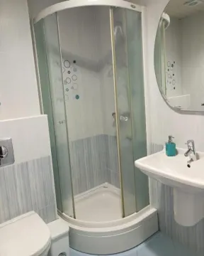 Bathroom with a shower cabin, washbasin, and mirror. - image 5