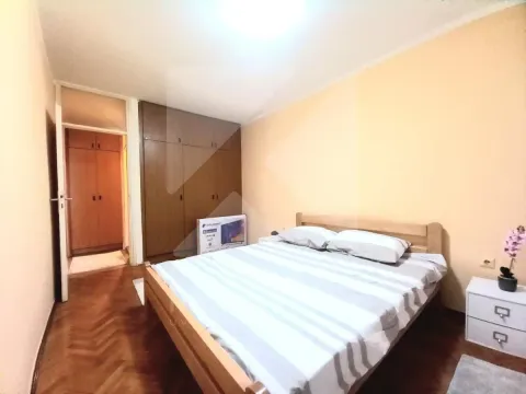 Namještena spavaća soba sa bračnim krevetom, plakarom i bijelim noćnim stolićem. - image 4