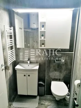 Small bathroom with a sink, toilet, and mirror. - image 9