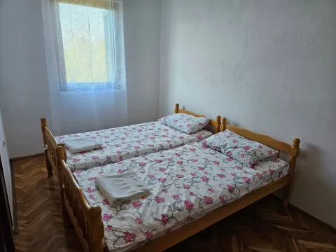 Bedroom with two wooden beds and a window. - image 8