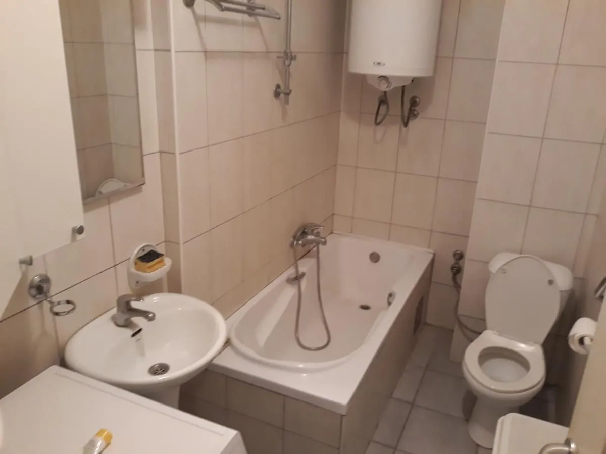 Kupatilo opremljeno kadom, umivaonikom i toaletom sa pločicama na zidovima.