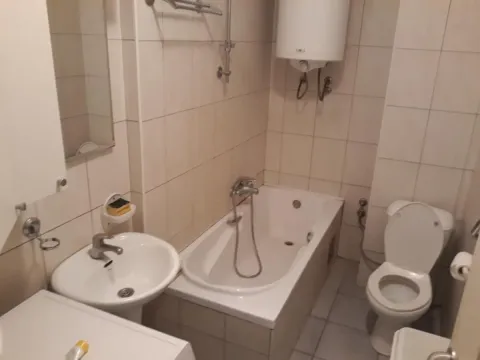 Kupatilo opremljeno kadom, umivaonikom i toaletom sa pločicama na zidovima. - image 12