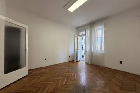 Empty room with parquet flooring and balcony access. - image 2