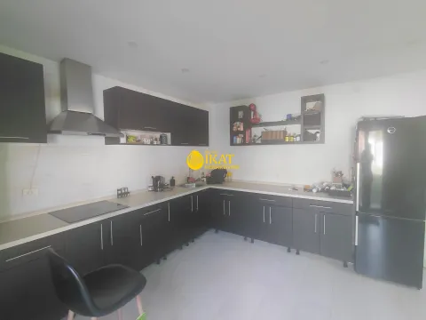 Opremljena kuhinja sa tamnim elementima i belim radnim površinama. - image 5