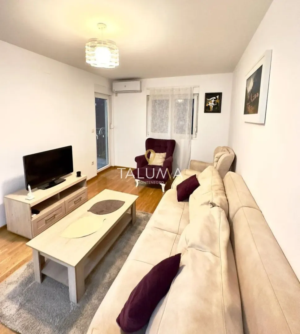 Living room with a sofa set, TV unit, and coffee table.