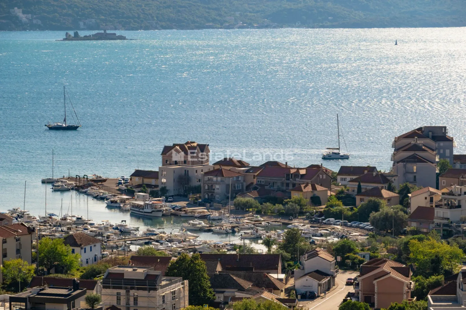 Pogled na primorsko naselje sa lukom i morem.