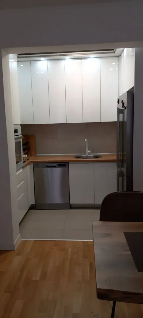 Modern kitchen with white cabinets and integrated appliances.