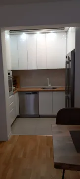 Modern kitchen with white cabinets and integrated appliances. - image 8