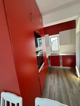 Kitchen with red and white cabinets and a built-in oven. - image 6