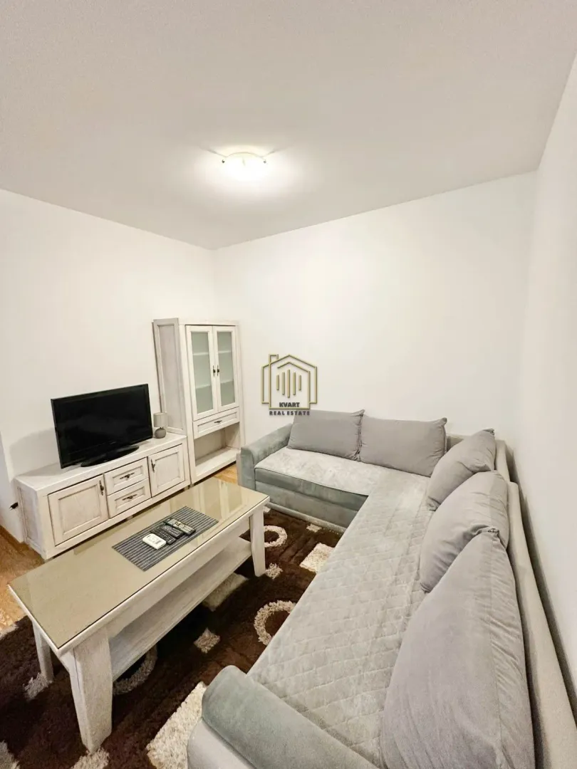 Living room with a sectional sofa, coffee table and TV.