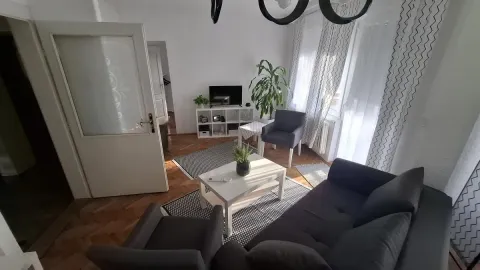 Dnevna soba sa garniturom za sedenje, stočićem i televizorom. - image 2