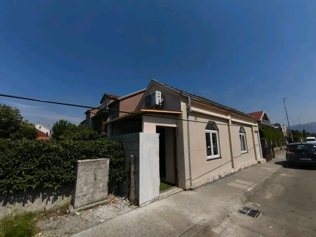 Pogled spolja na prizemnu kuću sa dvorištem i ulicom.