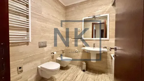 Bathroom covered with ceramic tiles featuring a sink, toilet, and bidet. - image 19