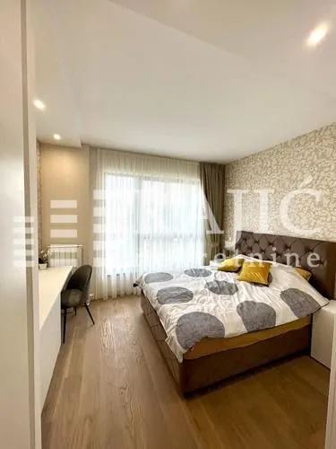 Furnished bedroom with a double bed and a desk.