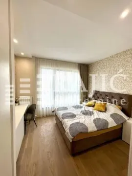 Furnished bedroom with a double bed and a desk. - image 9