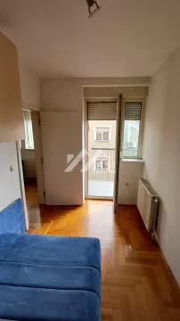 Smaller bedroom with parquet flooring and access to the balcony. - image 6