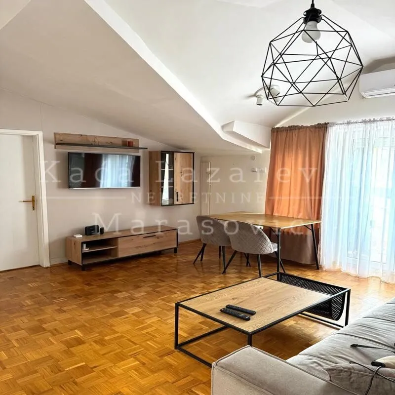 Living room with dining area and parquet flooring in the attic.