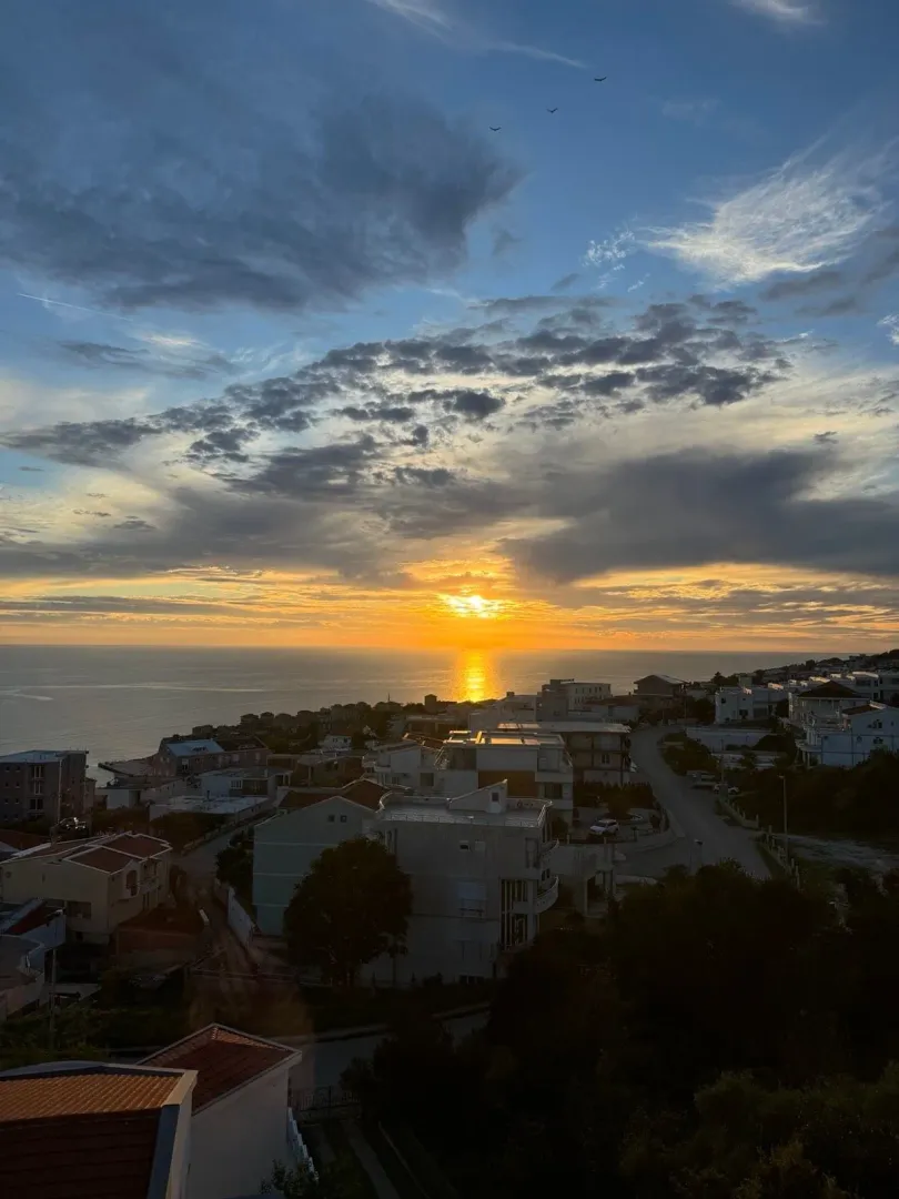Pogled na zalazak sunca iznad mora i naselja sa terase.