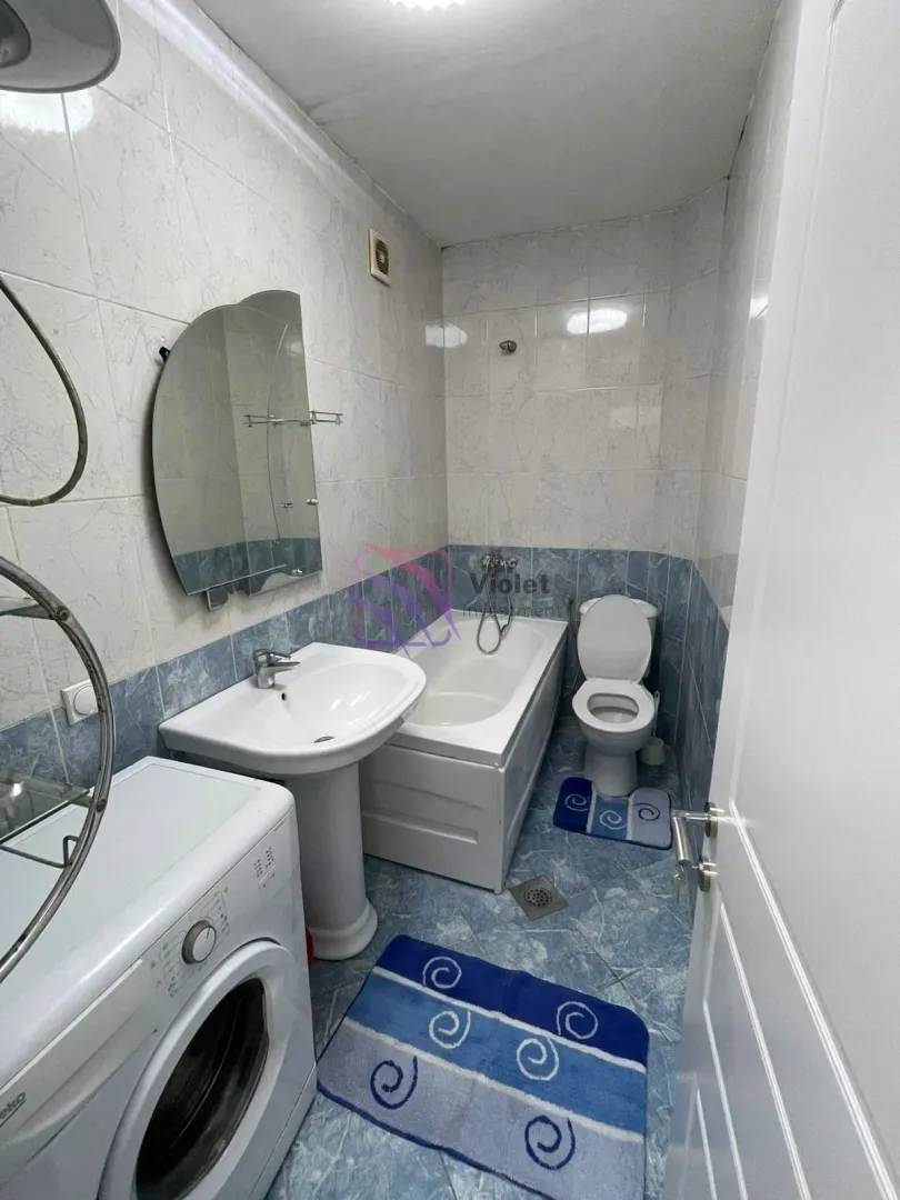 Bathroom equipped with a washbasin, bathtub, toilet, and washing machine.