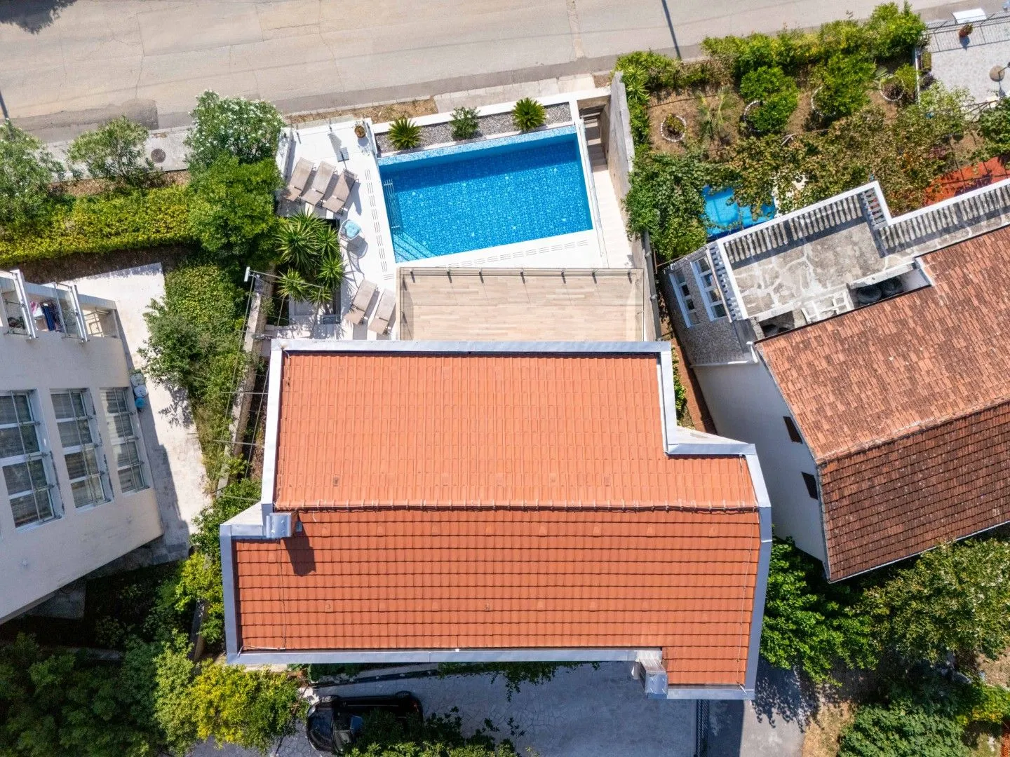 Pogled iz vazduha prikazuje kuću sa bazenom i dvorištem.