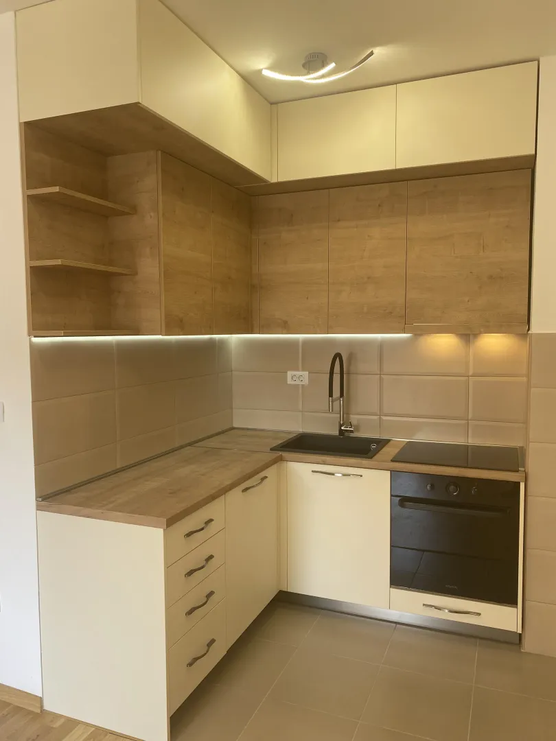 Modern kitchen with light wood cabinetry.