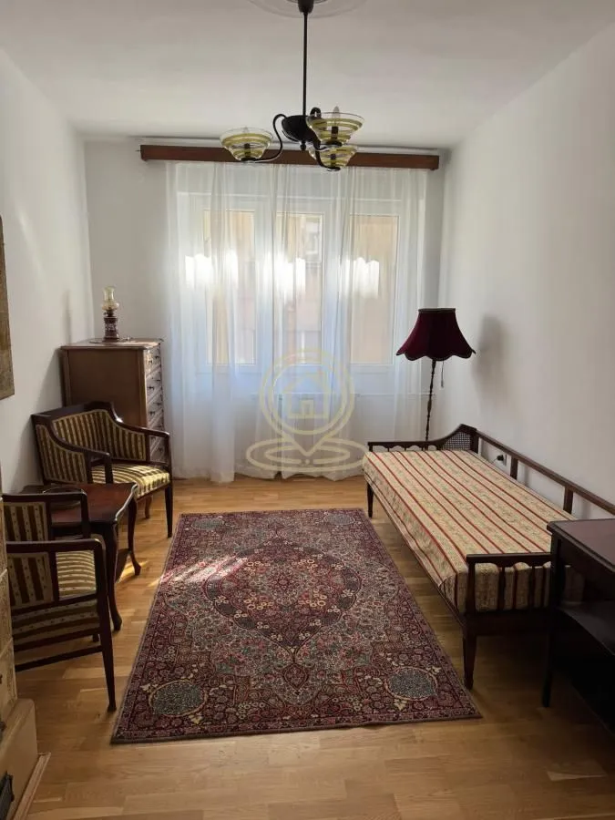 Furnished bedroom with a bed, armchairs, and a rug.