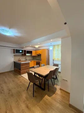 Kitchen with dining area and orange wooden elements. - image 2