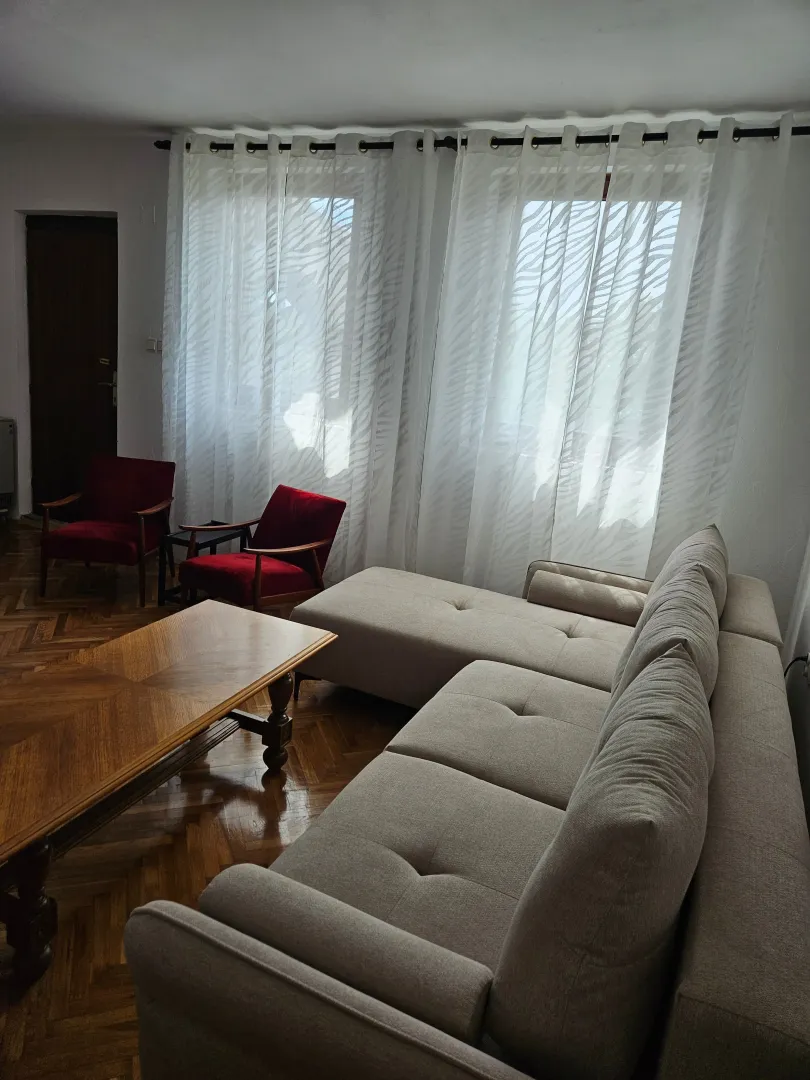 Living room with a sofa, armchairs, and a wooden coffee table.