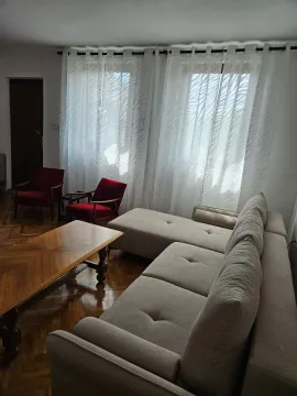 Living room with a sofa, armchairs, and a wooden coffee table. - image 4