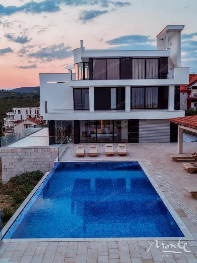 Exterior of a modern villa with a swimming pool and sun terrace.