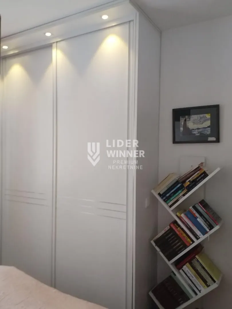 Bedroom with a large built-in wardrobe and a small bookshelf.