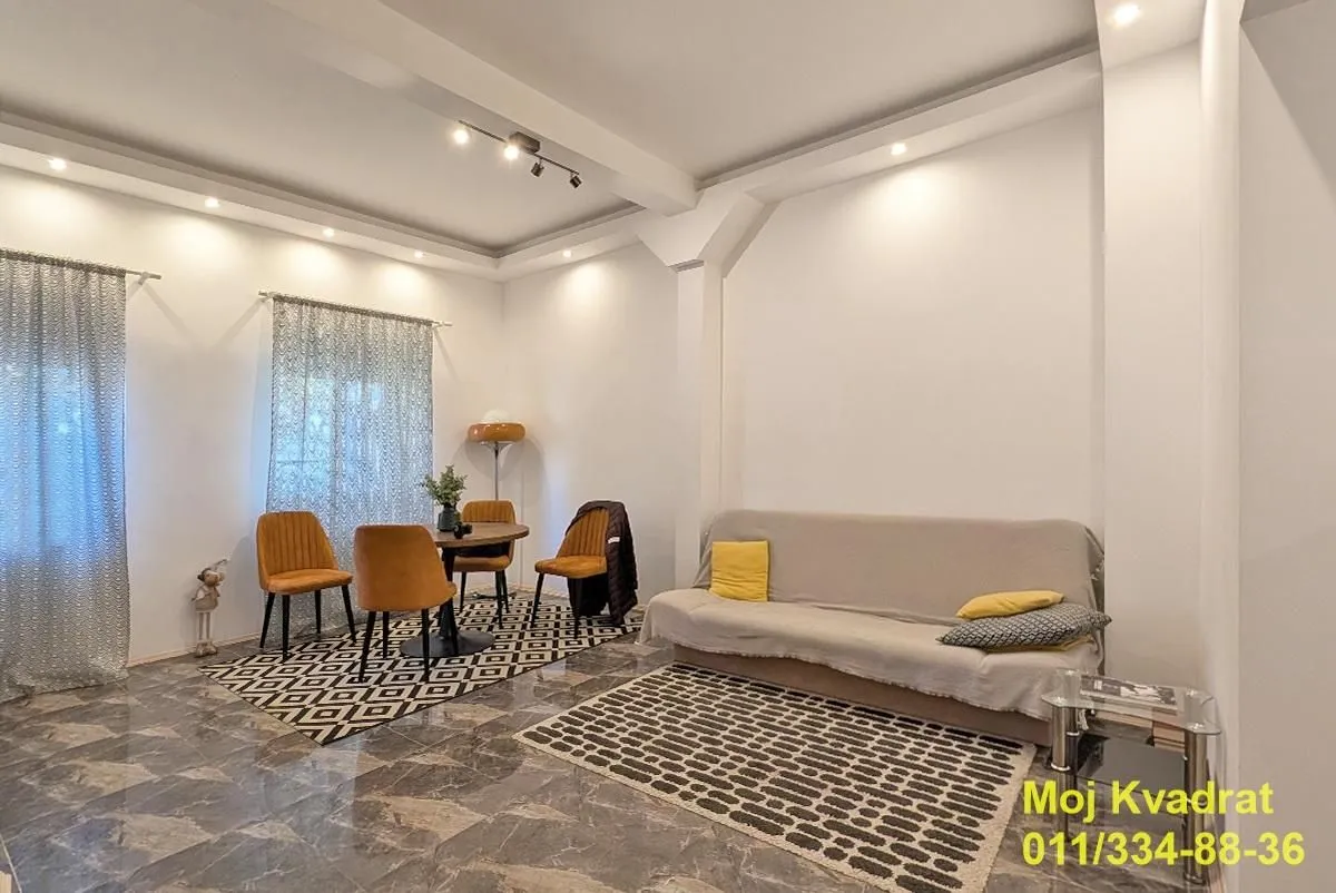 Living room with a sofa and a dining area.