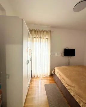 Namještena spavaća soba sa bračnim krevetom, garderoberom i televizorom na zidu. - image 11