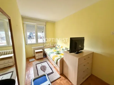 Manja spavaća soba sa krevetom, komodom i televizorom. - image 10
