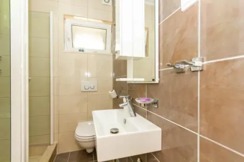 Smaller bathroom with a sink, toilet, and shower cabin. - image 8