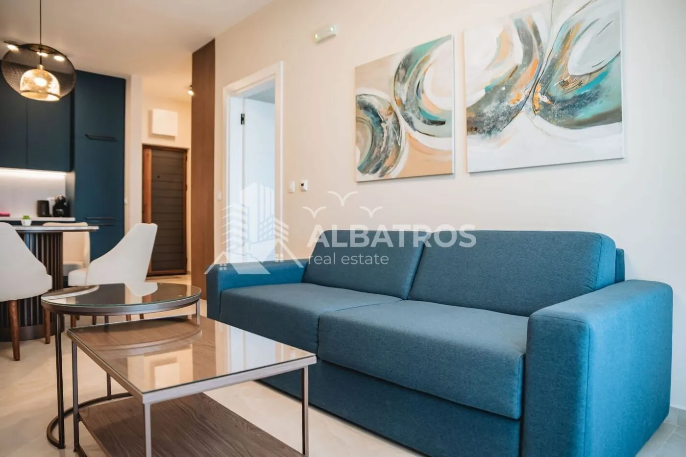 Living room with a blue sofa and glass coffee tables.