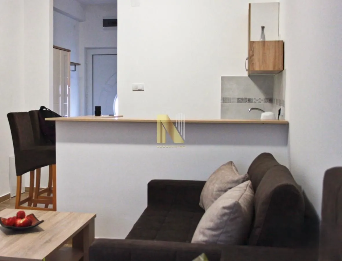 Living room with a sofa and a bar counter in the background.