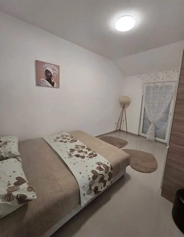 Uređena spavaća soba sa bračnim krevetom i ormarom.
