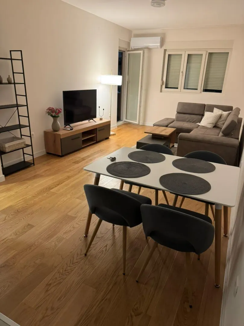 Spacious living room with a dining area, sectional sofa, and TV unit.