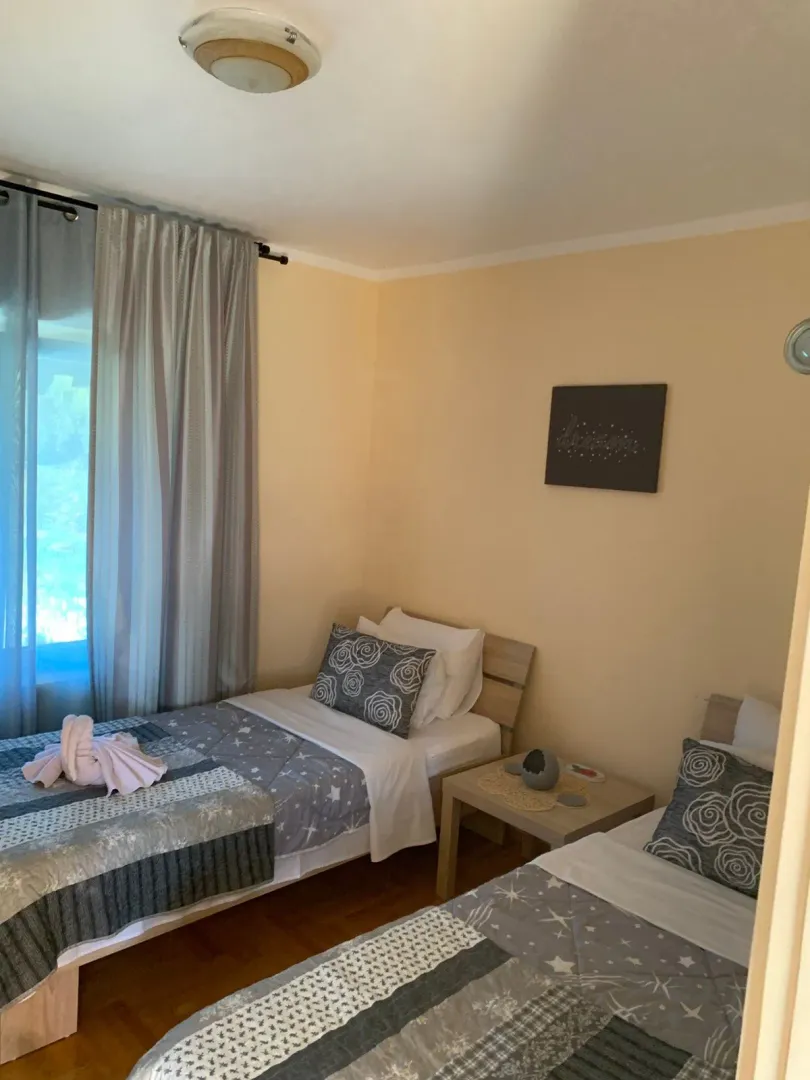 Bedroom with two single beds and a window with curtains.