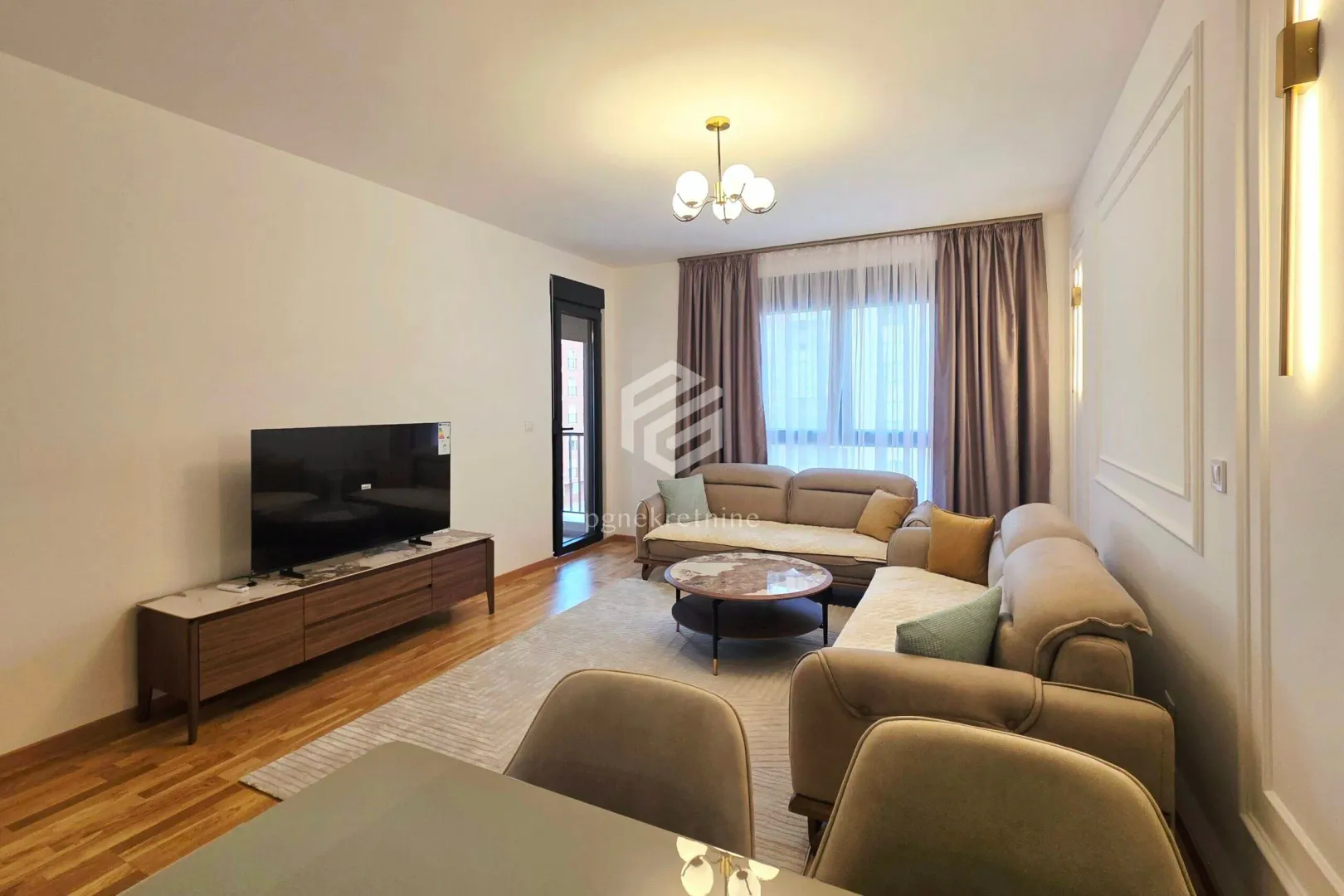 Living room with a sofa set, TV cabinet, and access to the terrace.